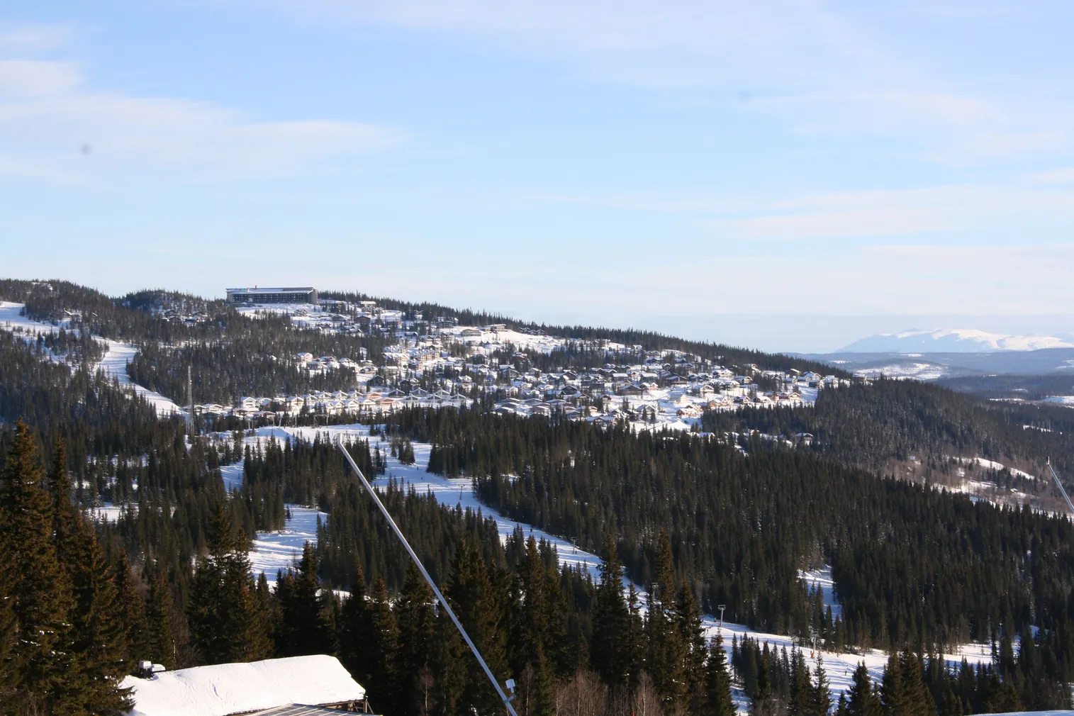 Vy över stugområdet i Åre Björnen och skidbackarna på Förberget en vinterdag.